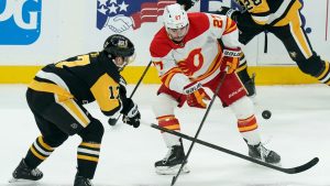 Pittsburgh Penguins' Bryan Rust (17) reaches for the puck against Calgary Flames' Matt Coronato (27) during the first period of an NHL hockey game Saturday, Nov. 30, 2024, in Pittsburgh. (Matt Freed/AP)