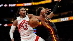 Toronto Raptors forward Collin Murray-Boyles (12) and Atlanta Hawks forward Jalen Johnson (1) vie for a loose ball during the second half of an NBA Cup basketball game, Friday, Nov. 7, 2025, in Atlanta. (Mike Stewart/AP)