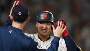 Kazuma Okamoto of Japan celebrates with Roki Sasaki of Japan after hitting a three-run home run during the third inning of the quarterfinal game between Italy and Japan at the World Baseball Classic (WBC) at Tokyo Dome in Tokyo, Japan, Thursday, March 16, 2023. (Toru Hanai/AP)