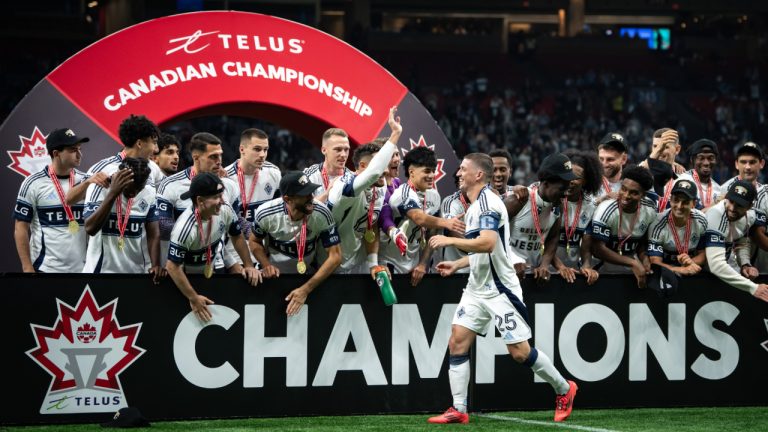 Vancouver Whitecaps' Ryan Gauld walks to a podium to hoist the Voyageurs Cup after defeating Vancouver FC in the Canadian Championship final match, in Vancouver, on Wednesday, October 1, 2025. (Ethan Cairns/CP)