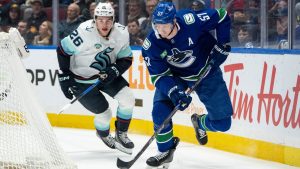 Seattle Kraken's Ryan Winterton (26) and Vancouver Canucks' Tyler Myers (57) vie for the puck during the first period of an NHL game in Vancouver, on Friday, January 2, 2026. THE CANADIAN PRESS/Ethan Cairns