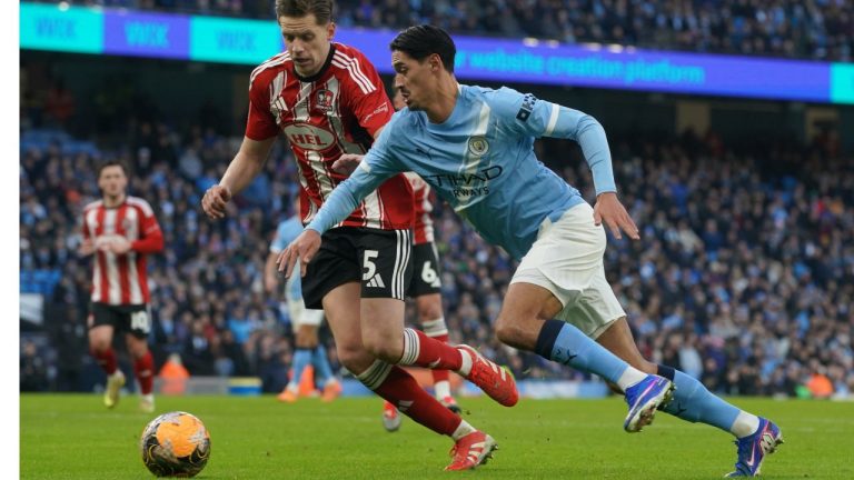 Manchester City's Tijjani Reijnders, right, and Exeter's Jack Fitzwater fight for the ball during the FA Cup third round match between Manchetster City and Exeter in Manchester, England Saturday, Jan. 10, 2026. (AP Photo/Ian Hodgson)