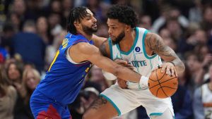 Denver Nuggets guard Jamal Murray, left, tries to knock the ball away from Charlotte Hornets forward Miles Bridges, right, in the first half of an NBA basketball game Sunday, Jan. 18, 2026, in Denver. (David Zalubowski/AP)