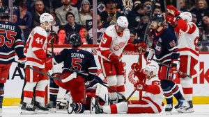 Detroit Red Wings' J.T. Compher (bottom right) celebrates as he scores against the Winnipeg Jets during second period NHL action in Winnipeg, Saturday, January 24, 2026. (John Woods/CP)