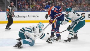San Jose Sharks' goalie Yaroslav Askarov (30) poke checks Edmonton Oilers' Mattias Janmark (13) as Mario Ferraro (38) defends during second period NHL action, in Edmonton on Thursday, Jan. 29, 2026. (Jason Franson/CP)
