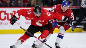 Canada's Cameron Reid, left, and Czechia forward Adam Titlbach compete for the puck during the first period of an IIHF World Junior Hockey Championship semifinals game, Sunday, Jan. 4, 2026, in St. Paul, Minn. (Matt Krohn/AP)