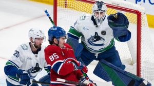 Vancouver Canucks goaltender Nikita Tolopilo (60) keeps an eye on the puck in front of Montreal Canadiens' Alexandre Texier (85) as Canucks' Marcus Pettersson (29) defends during second period NHL hockey action in Montreal on Monday, Jan. 12, 2026. (Christinne Muschi/CP)