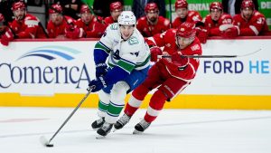 Vancouver Canucks defenseman Zeev Buium, left, moves the puck ahead of Detroit Red Wings right wing Patrick Kane during the first period of an NHL hockey game Thursday, January 8, 2026, in Detroit. (AP Photo/Ryan Sun)