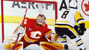 Pittsburgh Penguins' Thomas Novak, right, scores against Calgary Flames goalie Dustin Wolf during third period NHL hockey action in Calgary, Wednesday, Jan. 21, 2026. (Larry MacDougal/CP)