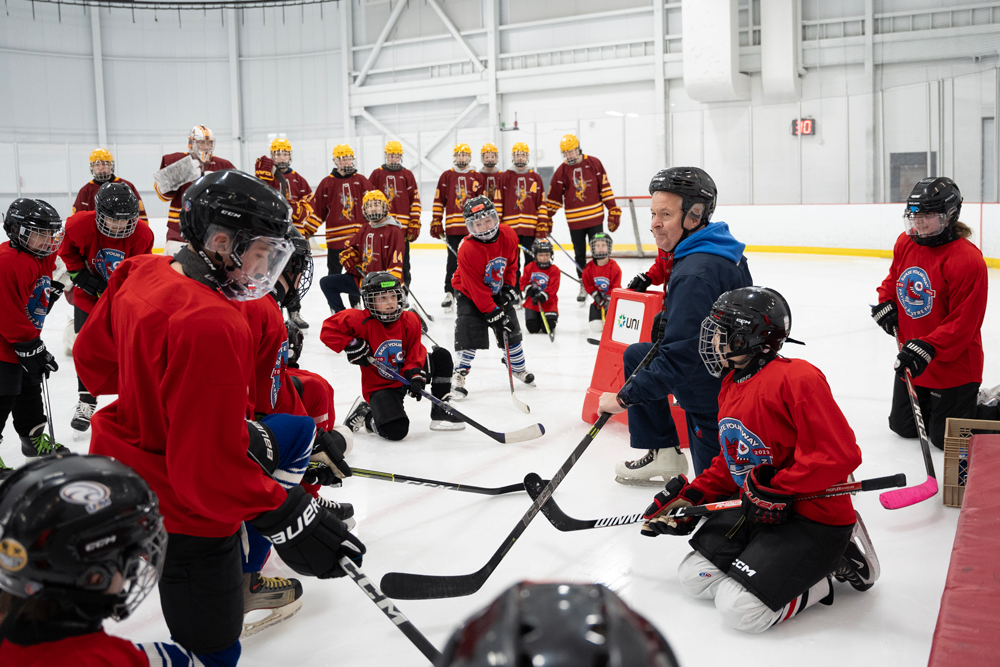 Participantes do Skate Your Way e membros do time de hóquei da escola Clément-Cormier Cavaliers se reúnem no gelo em Dieppe, NB (Foto de Darren Calabrese/Sportsnet)