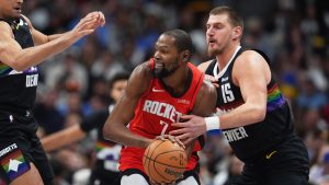 Houston Rockets forward Kevin Durant (7) looks to pass the ball as Denver Nuggets forward Spencer Jones (21) and center Nikola Jokić (15) defend in the first half of an NBA basketball game Saturday, Dec. 20, 2025, in Denver. (David Zalubowski/AP)