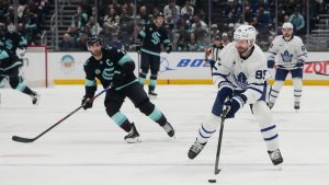Toronto Maple Leafs defenseman Oliver Ekman-Larsson, right, moves the puck against the Seattle Kraken during the first period of an NHL hockey game Friday, Jan. 30, 2026, in Seattle. (AP Photo/Lindsey Wasson)