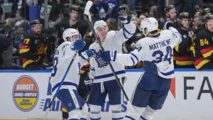 Toronto Maple Leafs' Nicholas Robertson, from left to right, Troy Stecher and Auston Matthews celebrate Matthews' goal and Toronto's win against the Vancouver Canucks during shootout NHL hockey action, in Vancouver, on Saturday, January 31, 2026. (Darryl Dyck/CP)