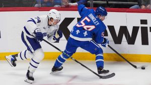 Colorado Avalanche centre Gavin Brindley, right, passes the puck as Toronto Maple Leafs centre Bobby McMann, left, defends in the first period of an NHL hockey game Monday, Jan. 12, 2026, in Denver. (David Zalubowski/AP)