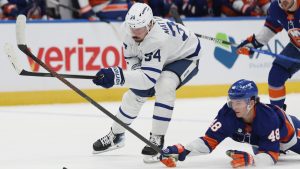 New York Islanders' Matthew Schaefer (48) reaches for the puck against Toronto Maple Leafs center Auston Matthews, left, during the first period of an NHL hockey game, Saturday, Jan. 3, 2026, in Elmont, N.Y. (Heather Khalifa/AP)