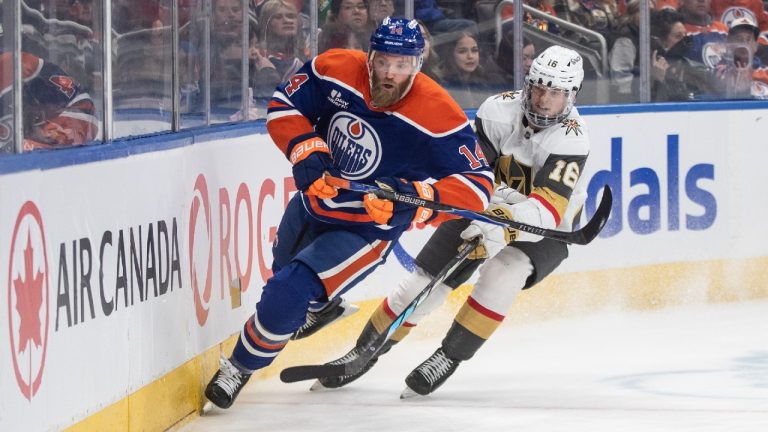 Vegas Golden Knights' Pavel Dorofeyev (16) and Edmonton Oilers' Mattias Ekholm (14) battle for the puck during third period NHL action, in Edmonton on Sunday, December 21, 2025. (Jason Franson/CP)
