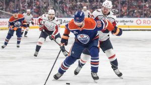 Washington Capitals' Anthony Beauvillier (72) and Edmonton Oilers' Jake Walman (96) battle for the puck during first period NHL action, in Edmonton on Saturday, Jan. 24, 2026. (Jason Franson/CP)