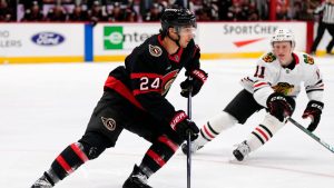 Ottawa Senators' Dylan Cozens (24) gets the puck out, in front of Chicago Blackhawks' Oliver Moore (11) during first period NHL hockey action in Ottawa, on Tuesday, April 15, 2025. (Justin Tang/CP)