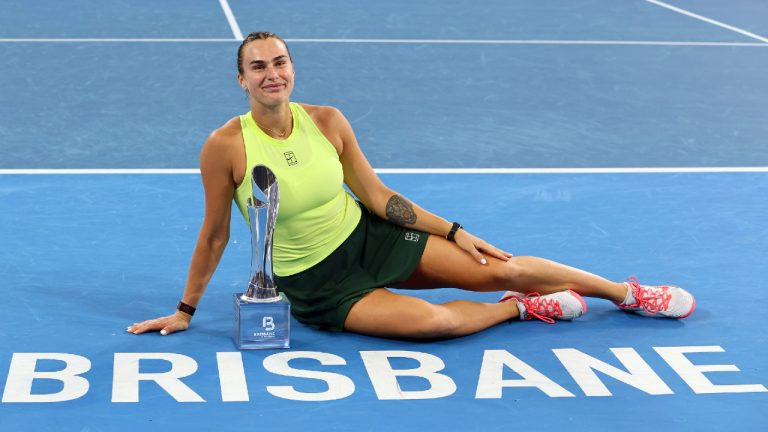 Aryna Sabalenka of Belarus poses with the winner's trophy after winning the women's final match against Marta Kostyuk of Ukraine 6-4, 6-3, at the Brisbane International tennis tournament in Brisbane, Australia, Sunday, Jan. 11, 2026. (Tertius Pickard/AP)