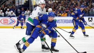 Buffalo Sabres centre Josh Norris (9) is pressured by Vancouver Canucks center Linus Karlsson (94) during the first period of an NHL hockey game Tuesday, Jan. 6, 2026, in Buffalo, N.Y.  (Jeffrey T. Barnes/AP)
