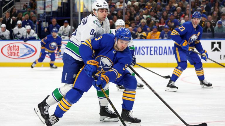 Buffalo Sabres centre Josh Norris (9) is pressured by Vancouver Canucks center Linus Karlsson (94) during the first period of an NHL hockey game Tuesday, Jan. 6, 2026, in Buffalo, N.Y.  (Jeffrey T. Barnes/AP)