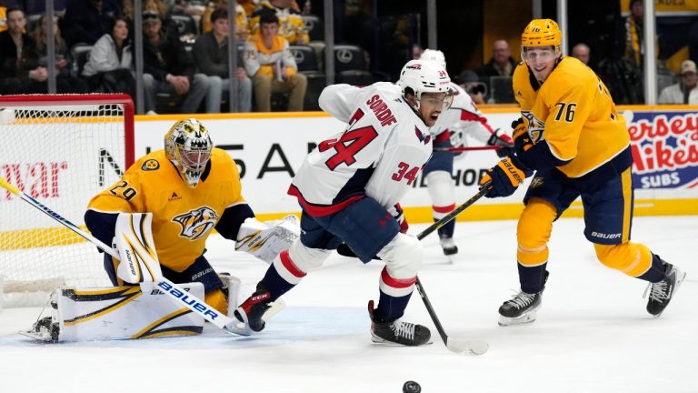 Washington Capitals right wing Justin Sourdif (34) watches a rebound along with Nashville Predators goaltender Justus Annunen (29) and defenseman Brady Skjei (76) during the first period of an NHL hockey game Sunday, Jan. 11, 2026, in Nashville, Tenn. (Mark Humphrey/AP)