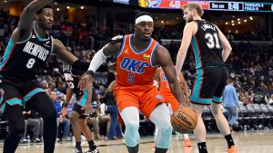 Oklahoma City Thunder guard Luguentz Dort (5) handles the ball ahead of Memphis Grizzlies forward Jaren Jackson Jr. (8) in the second half of an NBA basketball game Friday, Jan. 9, 2026, in Memphis, Tenn. (AP Photo/Brandon Dill)