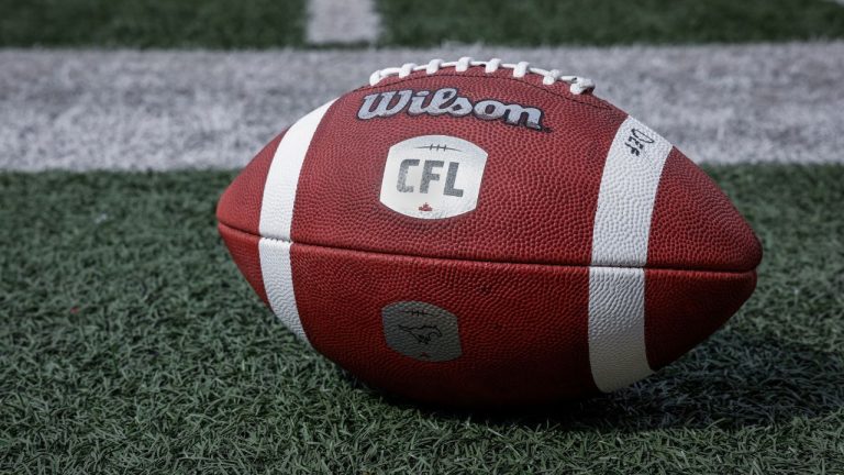 A football sits on the sidelines as the Calgary Stampeders runs drills during opening day of training camp in Calgary, Alta., Sunday, May 12, 2024. (Jeff McIntosh/CP)