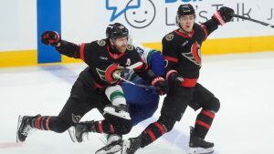 Ottawa Senators right wing Claude Giroux (28) and defenceman Jordan Spence (10) collide with Vancouver Canucks centre Max Sasson (63) during third period NHL action in Ottawa, Tuesday, Jan. 13, 2026. (Adrian Wyld/CP)