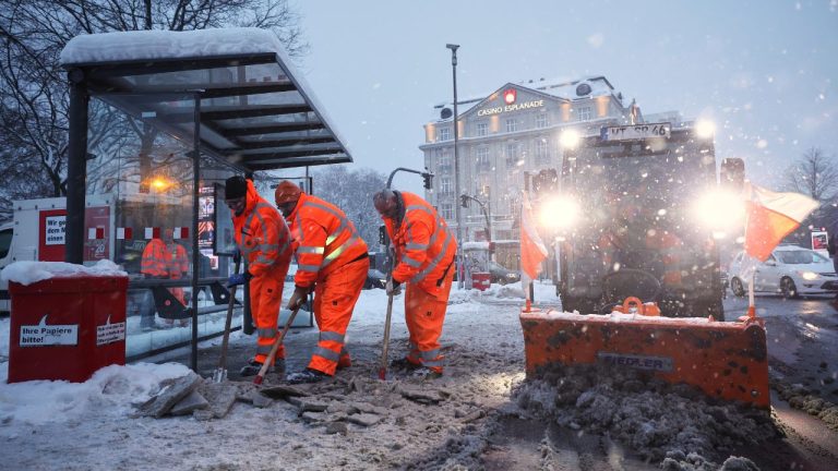 Hamburg municipal workers clear ice and snow from a bus stop at Stephansplatz, in Hamburg, Germany, Friday, Jan. 9, 2026. (Christian Charisius/AP)