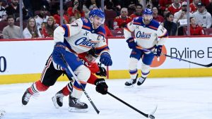 Edmonton Oilers centre Connor McDavid, front, and Chicago Blackhawks left wing Landon Slaggert (84) chase the puck during the first period of an NHL hockey game, Monday, Jan. 12, 2026, in Chicago. (Matt Marton/AP)