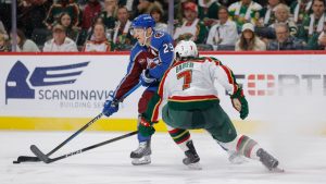 Colorado Avalanche centre Nathan MacKinnon skates with the puck while being defended by Minnesota Wild defenceman Brock Faber during the second period of an NHL game, Sunday, Dec. 21, 2025, in St. Paul, Minn. (AP Photo/Bailey Hillesheim)