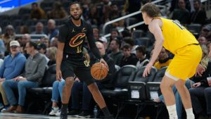 Cleveland Cavaliers guard Darius Garland, left, dribbles in front of Indiana Pacers guard Johnny Furphy during the first half of a game in Indianapolis, Tuesday, Jan. 6, 2026. (AP Photo/AJ Mast)