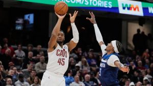 Cleveland Cavaliers guard Donovan Mitchell (45) shoots next to Minnesota Timberwolves forward Jaden McDaniels (3) in the second half of an NBA basketball game Sunday, Jan. 4, 2026, in Cleveland. (Sue Ogrocki/AP)