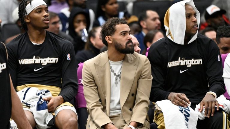 Washington Wizards newly acquired point guard Trae Young, center, sits on the bench in street clothes between guard Bilal Coulibaly, left, and forward Khris Middleton during the first half of an NBA basketball game against the New Orleans Pelicans, Friday, Jan. 9, 2026, in Washington. (John McDonnell/AP)