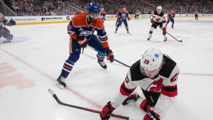 New Jersey Devils' Lenni Hameenaho (29) and Edmonton Oilers' Darnell Nurse (25) battle for the puck during first period NHL action, in Edmonton on Tuesday, Jan. 20, 2026. (Jason Franson/CP)
