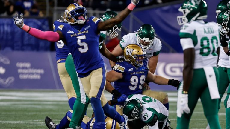 Winnipeg Blue Bombers’ Willie Jefferson (5) celebrates a sack on Saskatchewan Roughriders quarterback Jake Maier (9) by James Vaughters (93) and Cameron Lawson (99) during first half CFL action in Winnipeg, Friday, Oct. 17, 2025. (John Woods/CP)