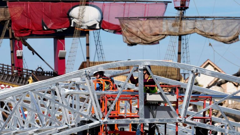 Workers build the canopy that will help protect the ice from the weather over an NHL hockey rink at Raymond James Stadium Wednesday, Jan. 21, 2026, in Tampa, Fla. (AP Photo/Chris O'Meara)