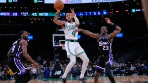 Boston Celtics guard Anfernee Simons (4) passes the ball while pressured by Sacramento Kings guard Keon Ellis (23) during the first half of an NBA game, Friday, Jan. 30, 2026, in Boston. (AP Photo/Charles Krupa)