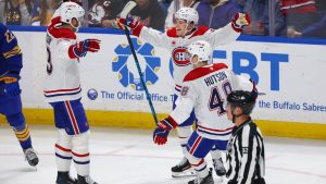 Montréal Canadiens right wing Cole Caufield (13) ,centre, celebrates his goal with defenceman Noah Dobson (53) ,left, and defenceman Lane Hutson (48), right, during the third period of an NHL hockey game against the Buffalo Sabres Saturday, Jan. 31, 2026, in Buffalo, N.Y. (AP Photo/Jeffrey T. Barnes)