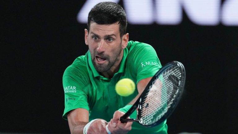 Novak Djokovic of Serbia plays a backhand return to Pedro Martinez of Spain in their first round match at the Australian Open in Melbourne, Australia, Monday, Jan. 19, 2026. (AP Photo/Aaron Favila)