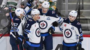 Winnipeg Jets defenseman Logan Stanley, second from right, celebrates with right wing Nino Niederreiter (62), center Vladislav Namestnikov (7) and center Cole Perfetti (91) after scoring against the Minnesota Wild during the second period of an NHL hockey game, Thursday, Jan. 15, 2025, in St. Paul, Minn. (Craig Lassig/AP)