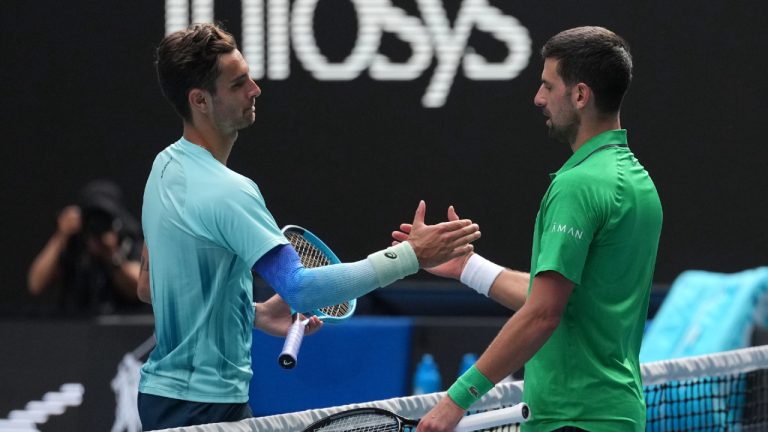 Lorenzo Musetti, left, of Italy shakes hands with Novak Djokovic of Serbia after retiring from their quarterfinal match at the Australian Open tennis championship in Melbourne, Australia, Wednesday, Jan. 28, 2026. (Dita Alangkara/AP)