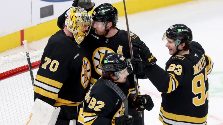 Boston Bruins goaltender Joonas Korpisalo (70) with centers Elias Lindholm (28), Marat Khusnutdinov (92) and Fraser Minten (93) celebrate after their team's win over the Pittsburgh Penguins in an NHL hockey game Sunday, Jan. 11, 2026, in Boston. (Mark Stockwell/AP)