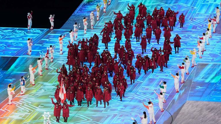 Canada flag-bearers Charles Hamelin (left) and Marie-Philip Poulin lead the Canadian athletes as they enter the stadium during the opening ceremony at the Beijing Winter Olympics in Beijing. (Paul Chiasson/THE CANADIAN PRESS)
