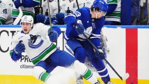 Vancouver Canucks' Linus Karlsson (94) and Toronto Maple Leafs' Matthew Knies (23) collide during first period NHL hockey action in Toronto on Saturday, Jan. 10, 2026. (Frank Gunn/CP)