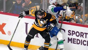 Pittsburgh Penguins' Sidney Crosby (87) checks Vancouver Canucks' Marcus Pettersson (29) off the puck during the first period of an NHL hockey game in Pittsburgh, Tuesday, Oct. 21, 2025. (Gene J. Puskar/AP)