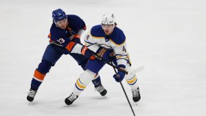 New York Islanders centre Mathew Barzal (13) and Buffalo Sabres defenseman Bowen Byram (4) go after the puck during the first period of an NHL hockey game, Saturday, Jan. 24, 2026, in Elmont, N.Y. (Heather Khalifa/AP)