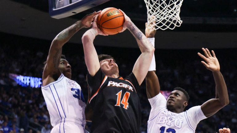 Pacific centre Isaac Jack (14) goes to the basket against BYU guard Kennard Davis Jr. (30) and center Keba Keita (13) during the second half of an NCAA basketball game, Tuesday, Dec. 16, 2025, in Provo, Utah. (Rob Gray/AP Photo)