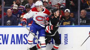 Buffalo Sabres right wing Jack Quinn (22) is checked by Montréal Canadiens defenseman Kaiden Guhle (21) during the second period of an NHL hockey game Thursday, Jan. 15, 2026, in Buffalo, N.Y. (Jeffrey T. Barnes/AP)